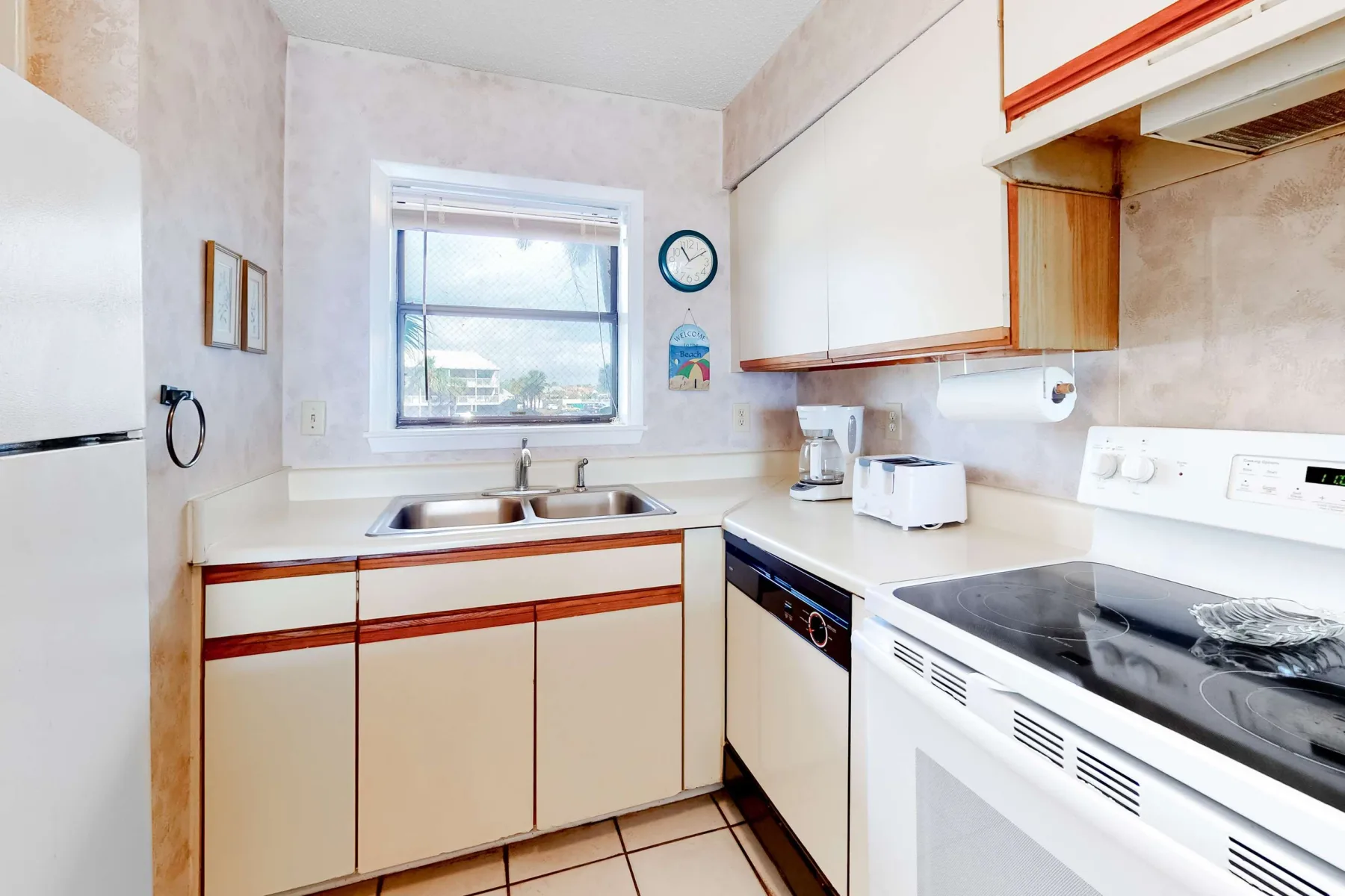 Una cocina compacta con una ventana sobre el fregadero y una estufa en la encimera.
