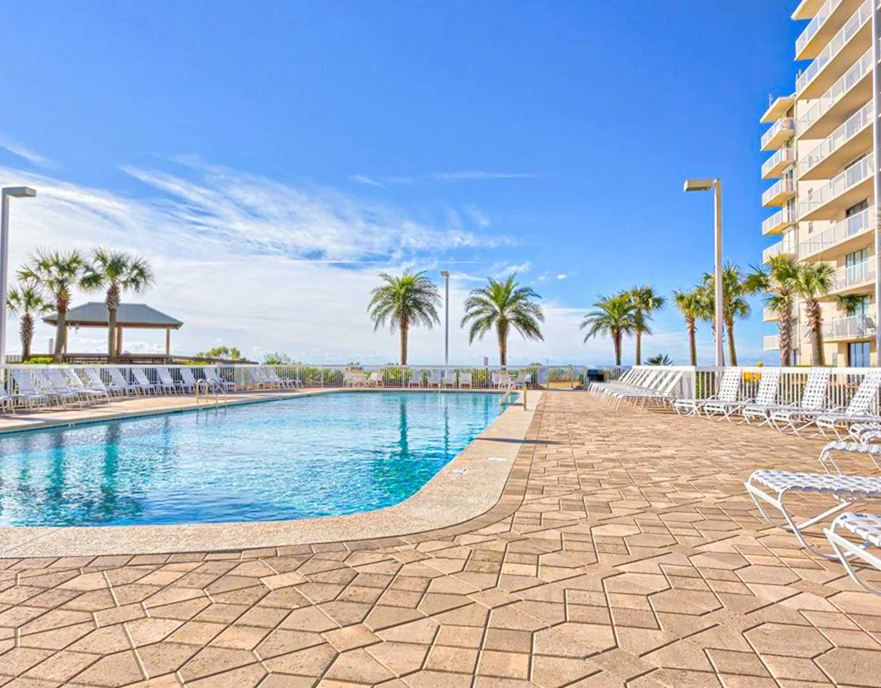 Zona común: Piscina al aire libre junto a una terraza pavimentada con asientos.