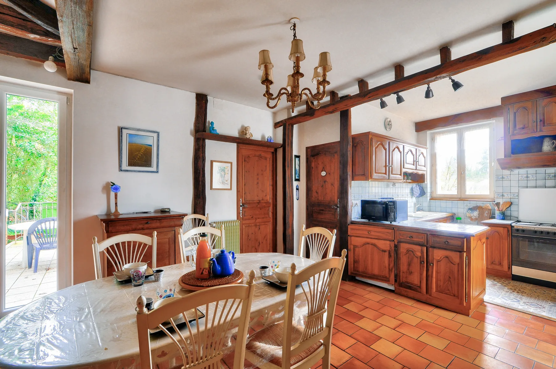 Un comedor con una mesa de madera junto a una cocina.