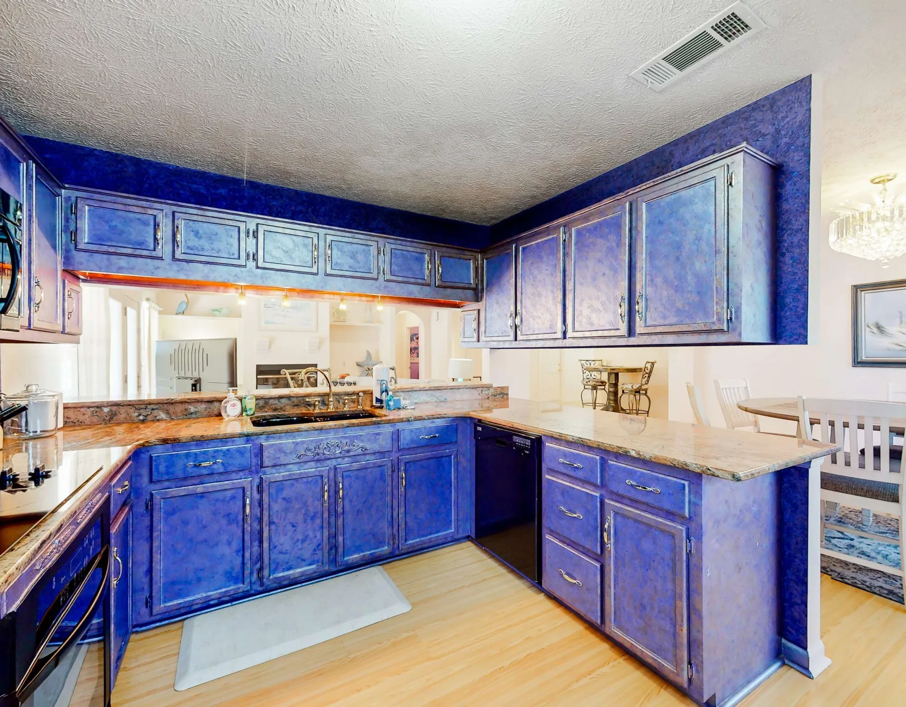A kitchen with blue cabinets and a light-colored countertop.
