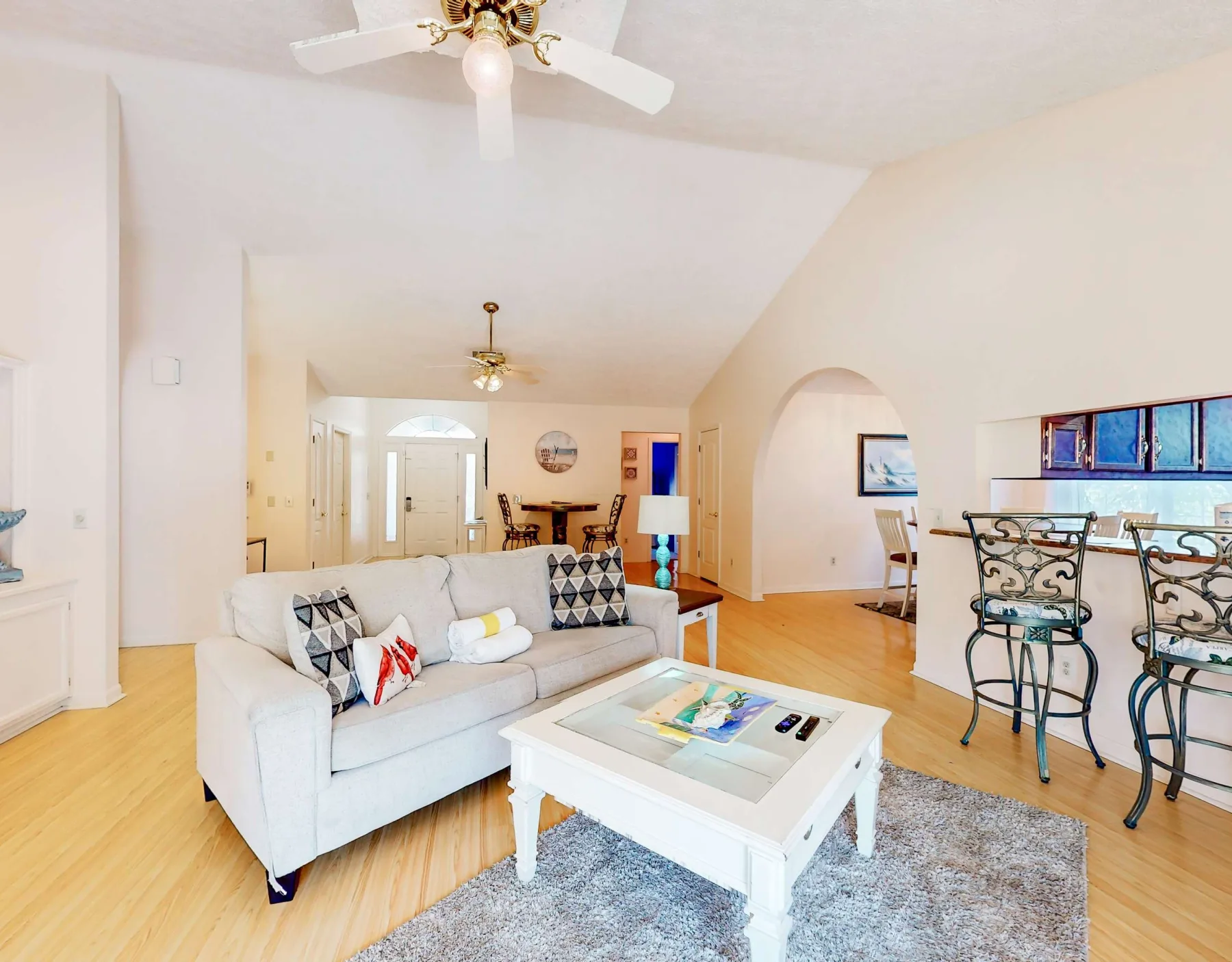 A bright living room with a seating area, coffee table, and dining space.