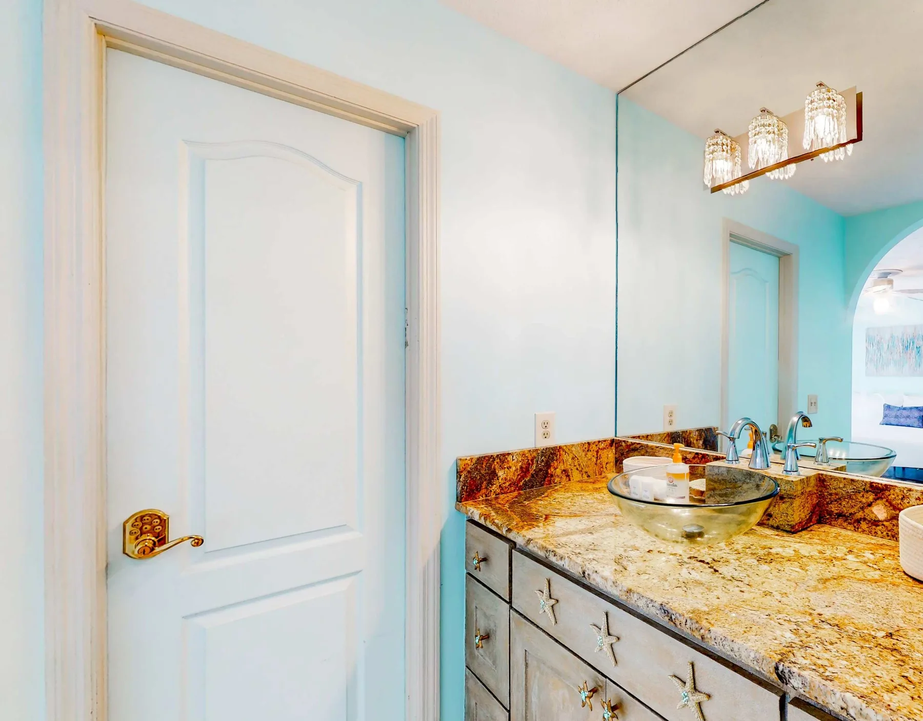 A bathroom vanity with a wide countertop and a large wall mirror.