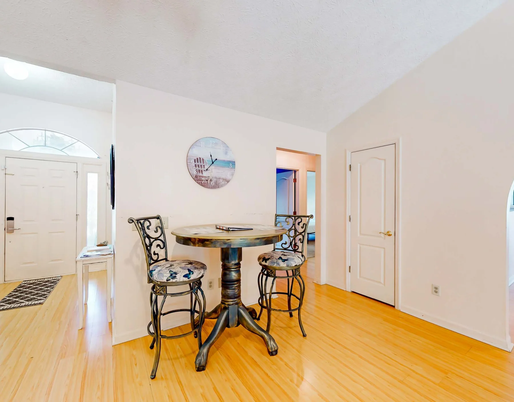 A bright dining nook with a round table and two decorative chairs.