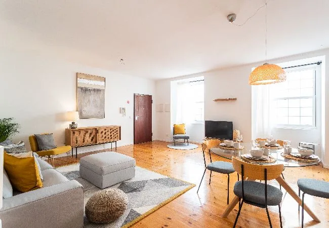 A bright living and dining area with seating, a television, and a dining table.