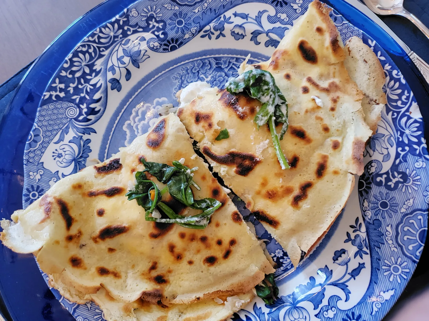 Representative hotel space: A plate of flatbread topped with fresh greens sits on a patterned dish.