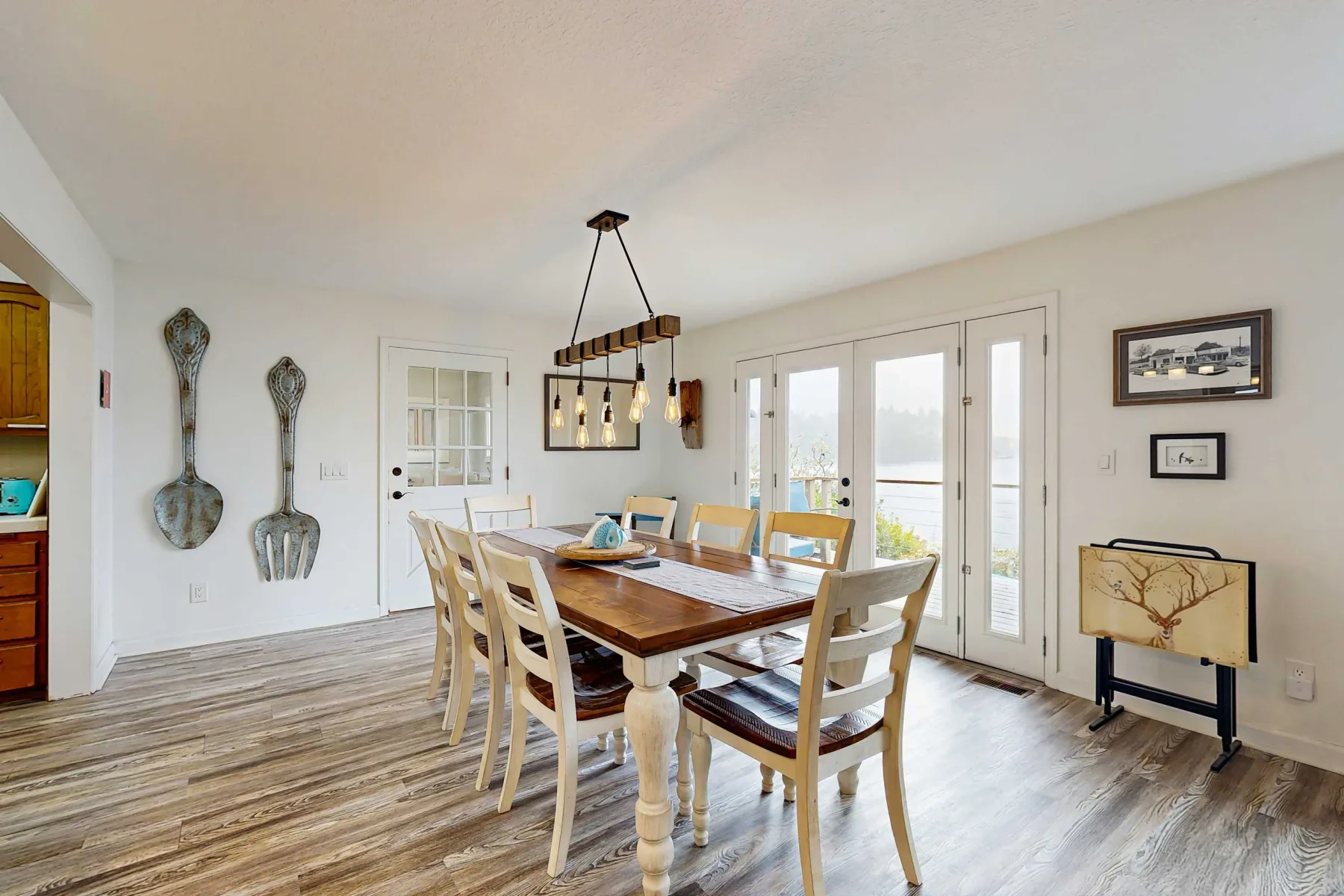 Un comedor luminoso con una mesa de madera y puertas de vidrio con vistas al exterior.