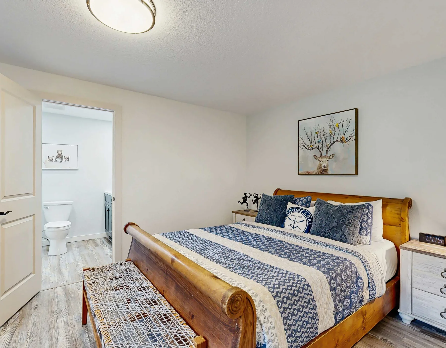 Dormitorio con una cama de madera vestida con ropa de cama estampada en azul y blanco.
