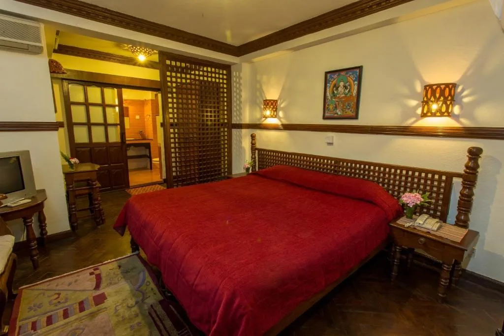 Espacio representativo del hotel: Dormitorio con una cama grande cubierta con ropa de cama roja.
