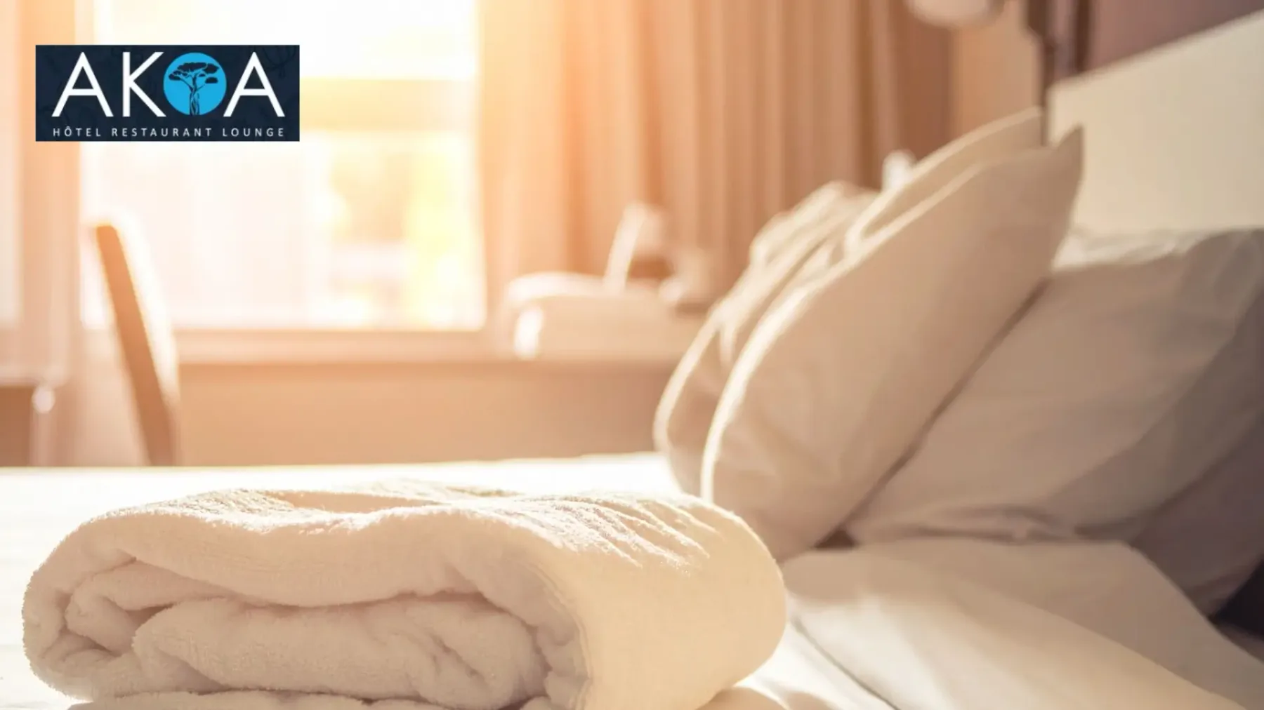 Representative hotel space: A bed with white linens and pillows sits beside a sunlit window.