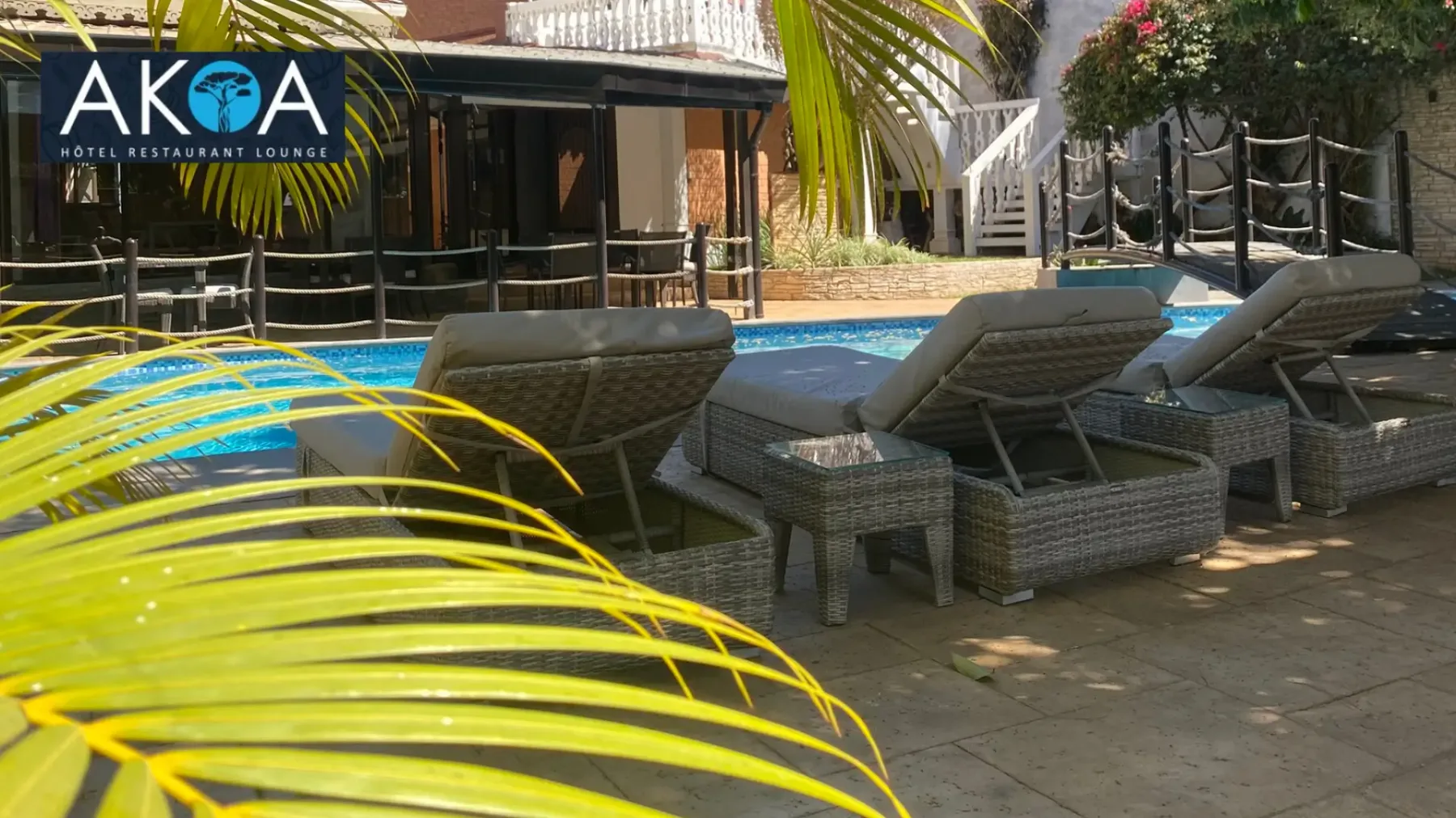 Representative hotel space: An outdoor poolside seating area with lounge chairs beside the water.