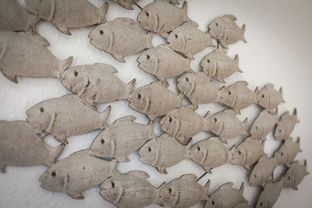 A wall decoration made of many small fish shapes.