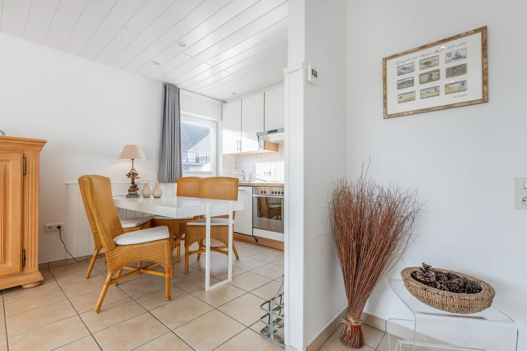 A bright dining area with a table and woven seating beside the kitchen.