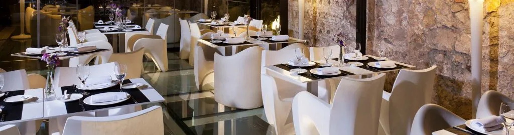 Representative hotel space: A restaurant dining area with set tables and upholstered seating.