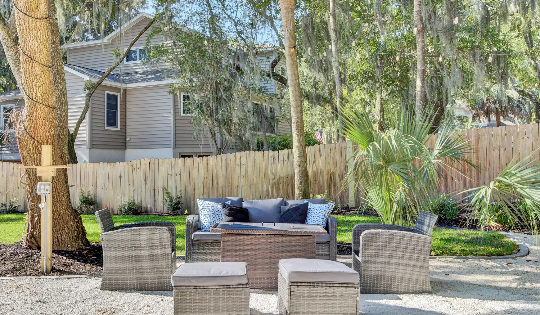 An outdoor patio seating area with woven chairs and a low table.