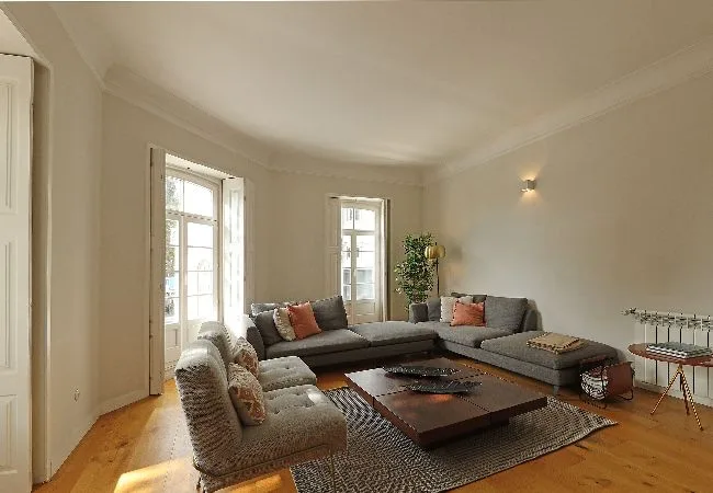 A bright living room with seating arranged around a low table and rug.