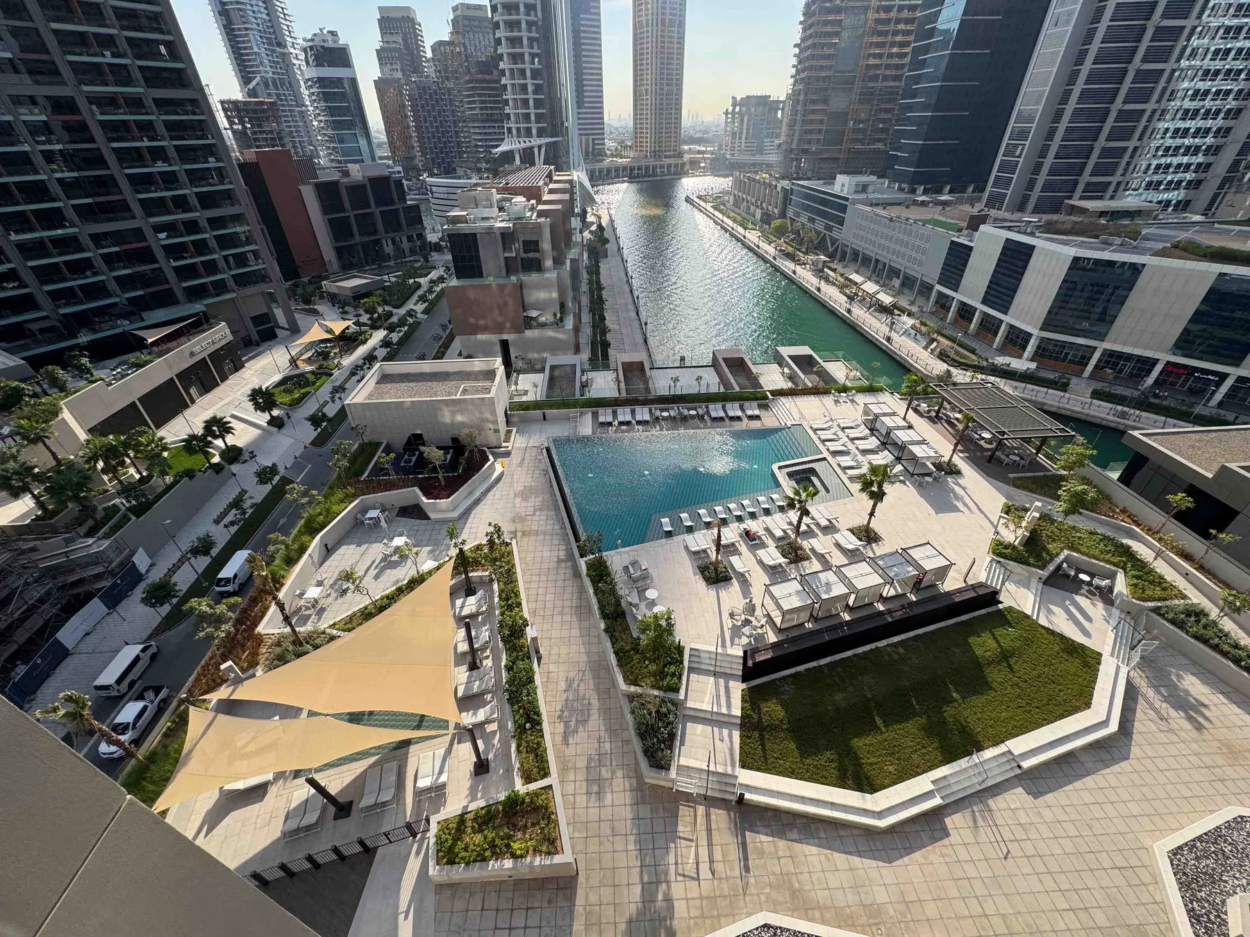 Una piscina en la azotea y una zona de asientos dan a un canal entre edificios altos.