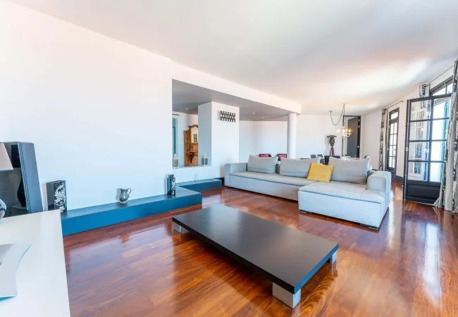 A bright living room with a sectional seating area and a low coffee table.
