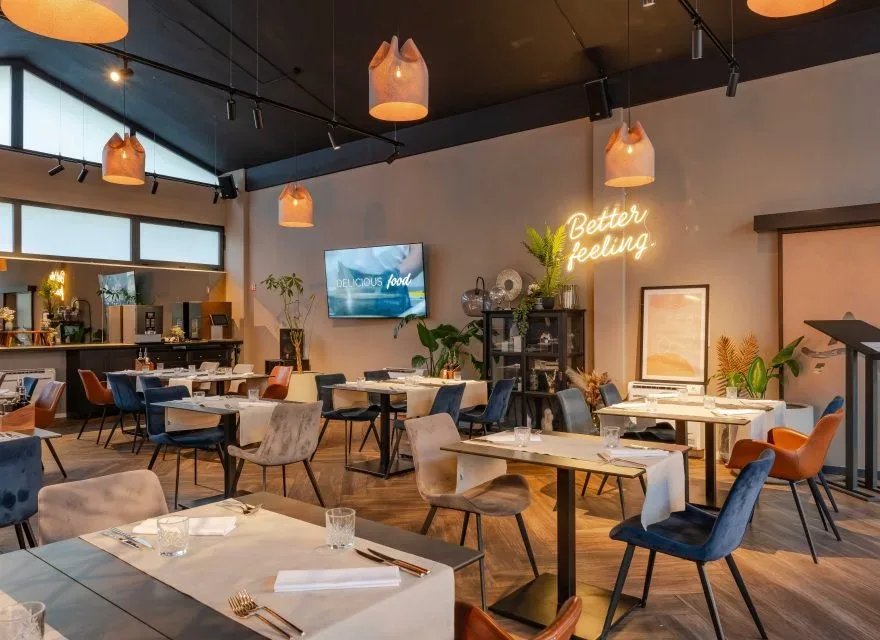 Espacio representativo del hotel: Comedor con mesas, asientos variados y lámparas colgantes.