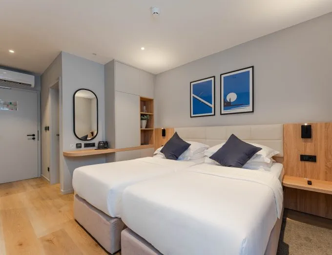 Espacio representativo del hotel: Un dormitorio luminoso con una cama grande, mesas de noche y cuadros en la pared.