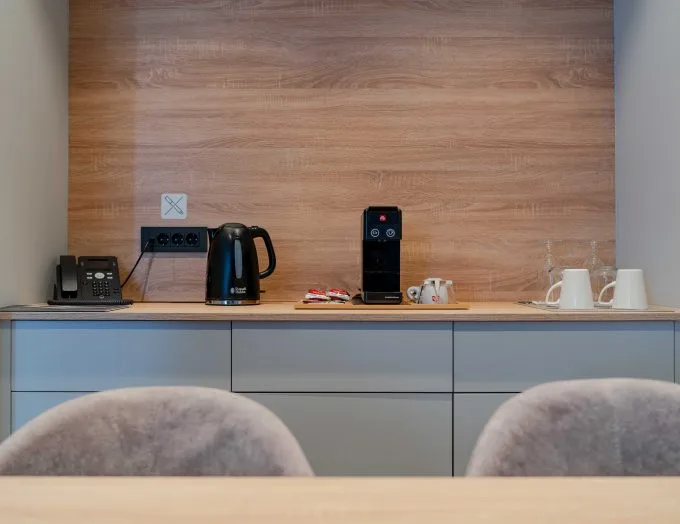 Espacio representativo del hotel: Una estación de bebidas de hotel con cafetera, hervidor y tazas.