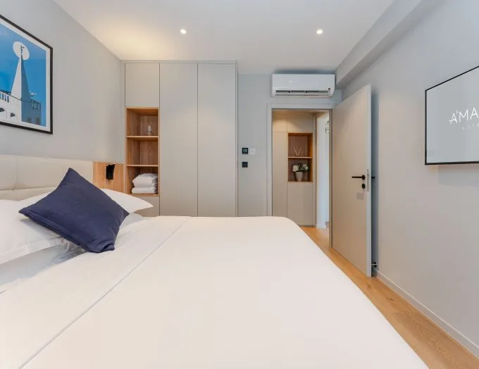 Espacio representativo del hotel: Un dormitorio luminoso con una cama bien hecha y armarios empotrados.