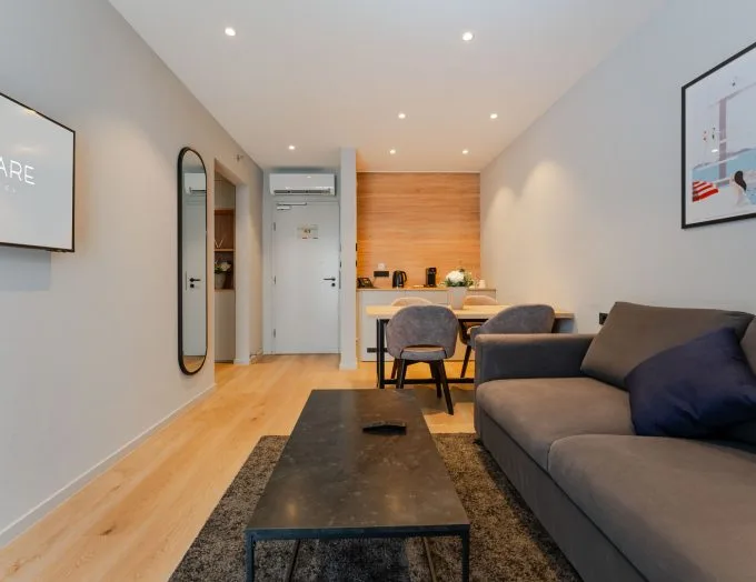 Espacio representativo del hotel: Una luminosa sala de estar y comedor con sofá y mesa.