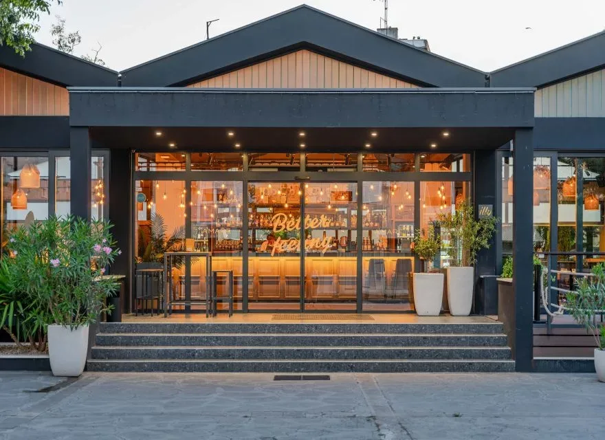 Espacio representativo del hotel: Entrada de un edificio moderno con escalones amplios y puertas de vidrio.