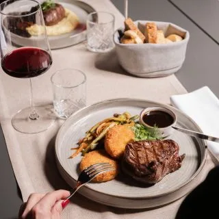 Espacio representativo del hotel: Escena de comedor con comida servida y bebidas sobre una mesa.