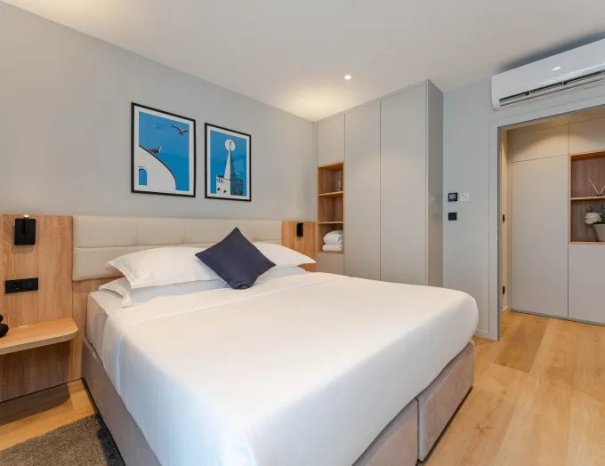 Espacio representativo del hotel: Dormitorio con una cama tendida y láminas enmarcadas en la pared.