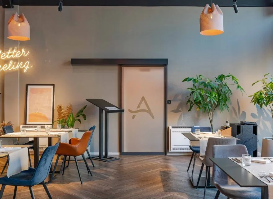 Espacio representativo del hotel: Un comedor moderno con mesas, sillas y lámparas colgantes.