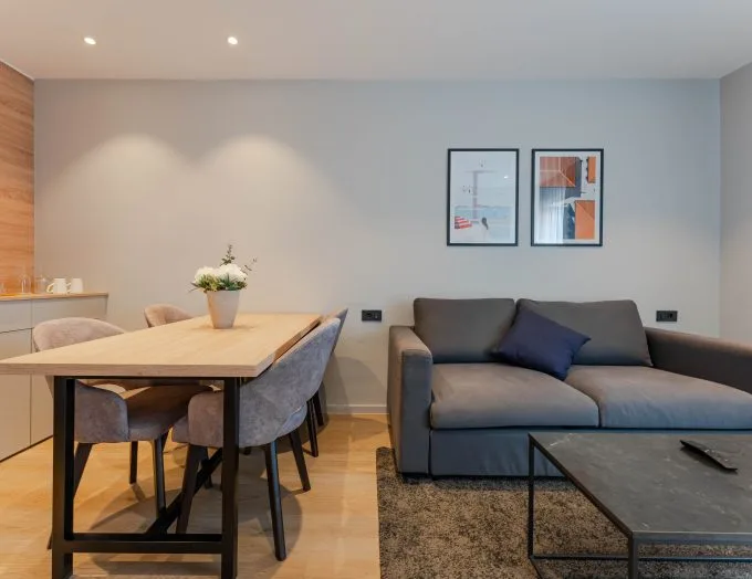 Espacio representativo del hotel: Una zona moderna de estar y comedor con mesa, asientos y cuadros enmarcados.