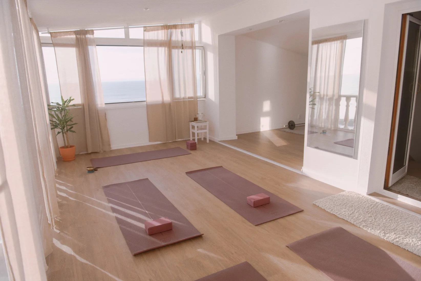 Espacio representativo del hotel: Una sala luminosa con esterillas de yoga sobre el suelo junto a grandes ventanas.