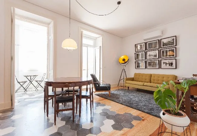 A bright living and dining area with a table, seating, and framed wall art.