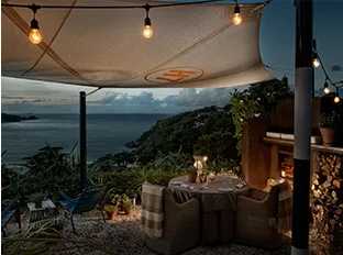 Espacio representativo del hotel: Zona de asientos al aire libre bajo un toldo con vistas al agua.