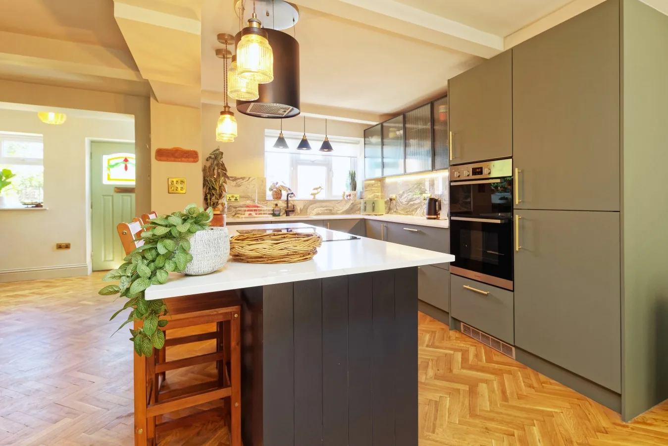 A bright modern kitchen with a central island and built-in appliances.