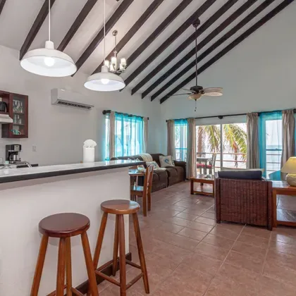 Espacio representativo del hotel: Sala de estar diáfana con una barra de cocina y asientos junto a las ventanas.