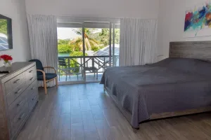 Espacio representativo del hotel: Un dormitorio con una cama grande y puertas corredizas de vidrio que dan a un balcón.