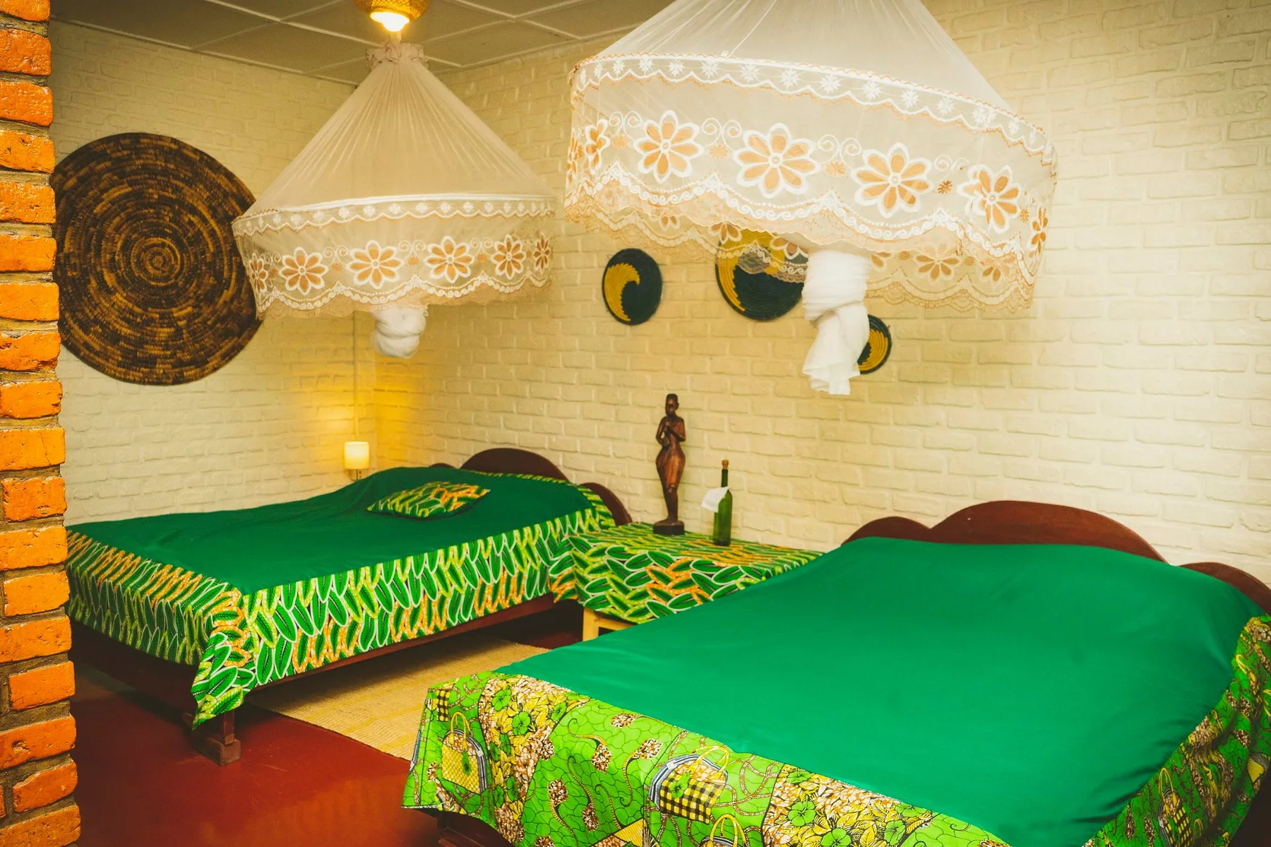 Espacio representativo del hotel: Un dormitorio con dos camas cubiertas con ropa de cama verde brillante.