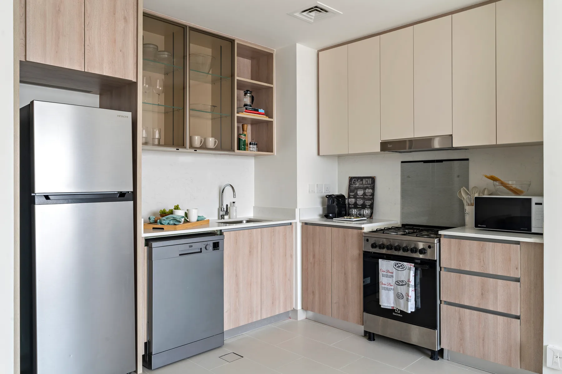 Una cocina moderna con gabinetes de madera clara y electrodomésticos de acero inoxidable.