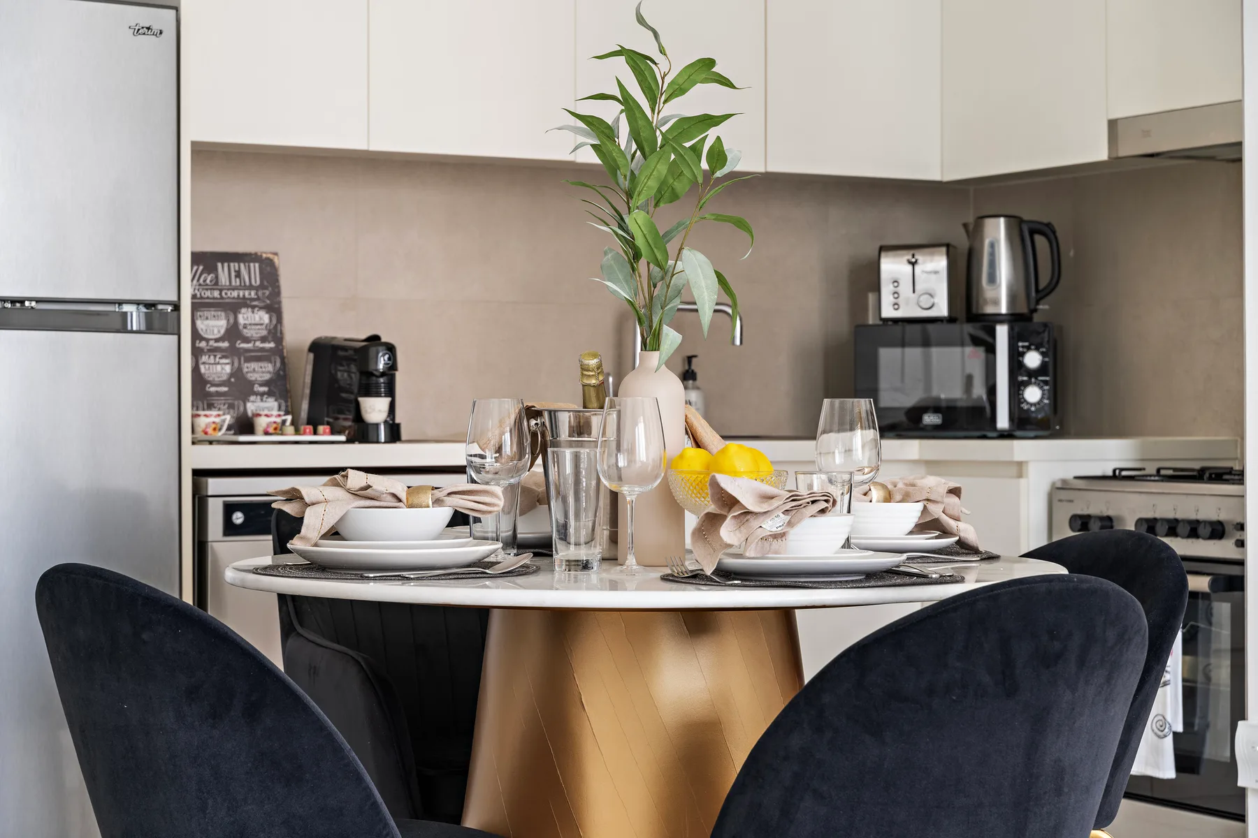Una mesa puesta con platos y flores está en una cocina.