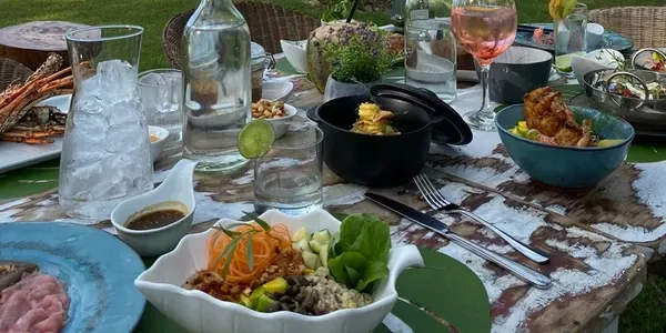 Espacio representativo del hotel: Una mesa de comedor está preparada con cuencos de comida, bebidas y fuentes.