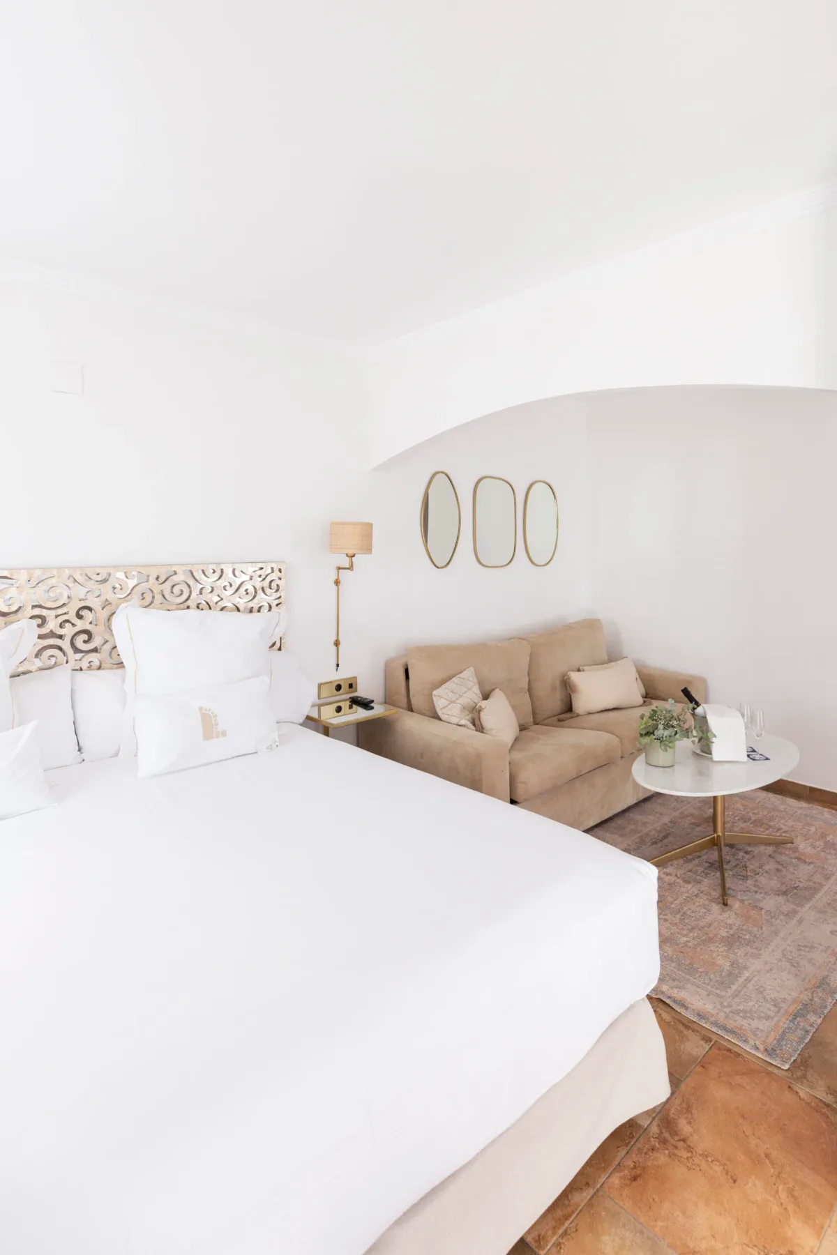 Espacio representativo del hotel: Un dormitorio luminoso con una cama grande y una pequeña zona de estar.