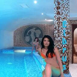 Representative hotel space: An indoor pool beside a mosaic-tiled wall.