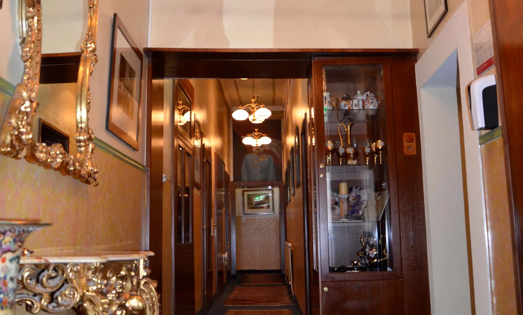 Representative hotel space: A warmly lit hotel hallway with dark wood trim and display cabinets.