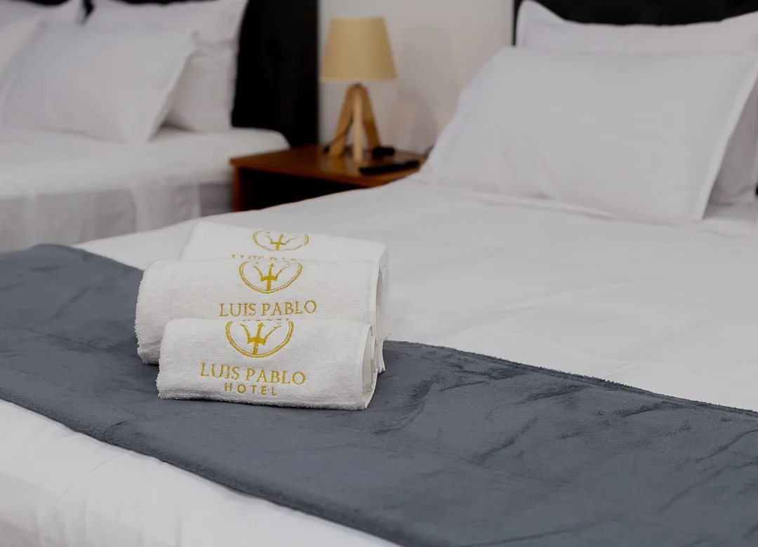 Espacio representativo del hotel: Un dormitorio de hotel con camas tendidas y toallas dobladas sobre la cama delantera.