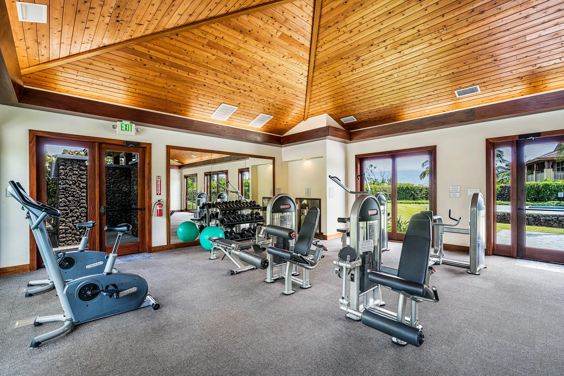 Zona común: Una sala de ejercicios con equipos de entrenamiento y ventanas grandes.