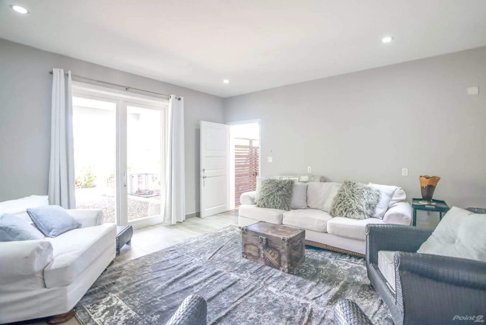 A bright living room with seating around a coffee table and large windows.