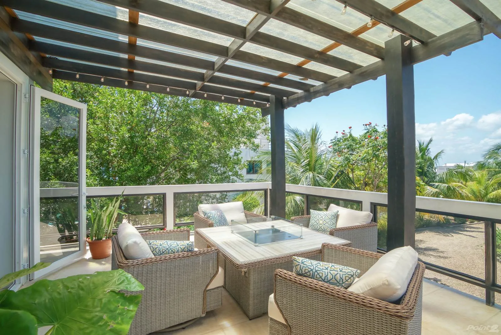 A covered outdoor seating area with a table and garden views.