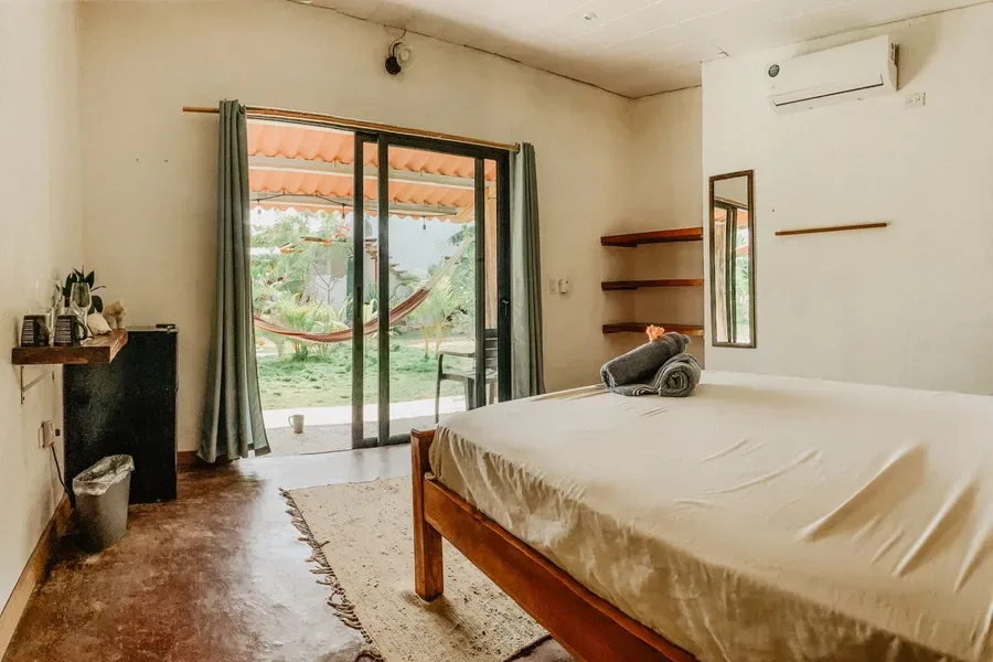 Representative hotel space: A bedroom with a bed beside glass doors opening onto a garden.