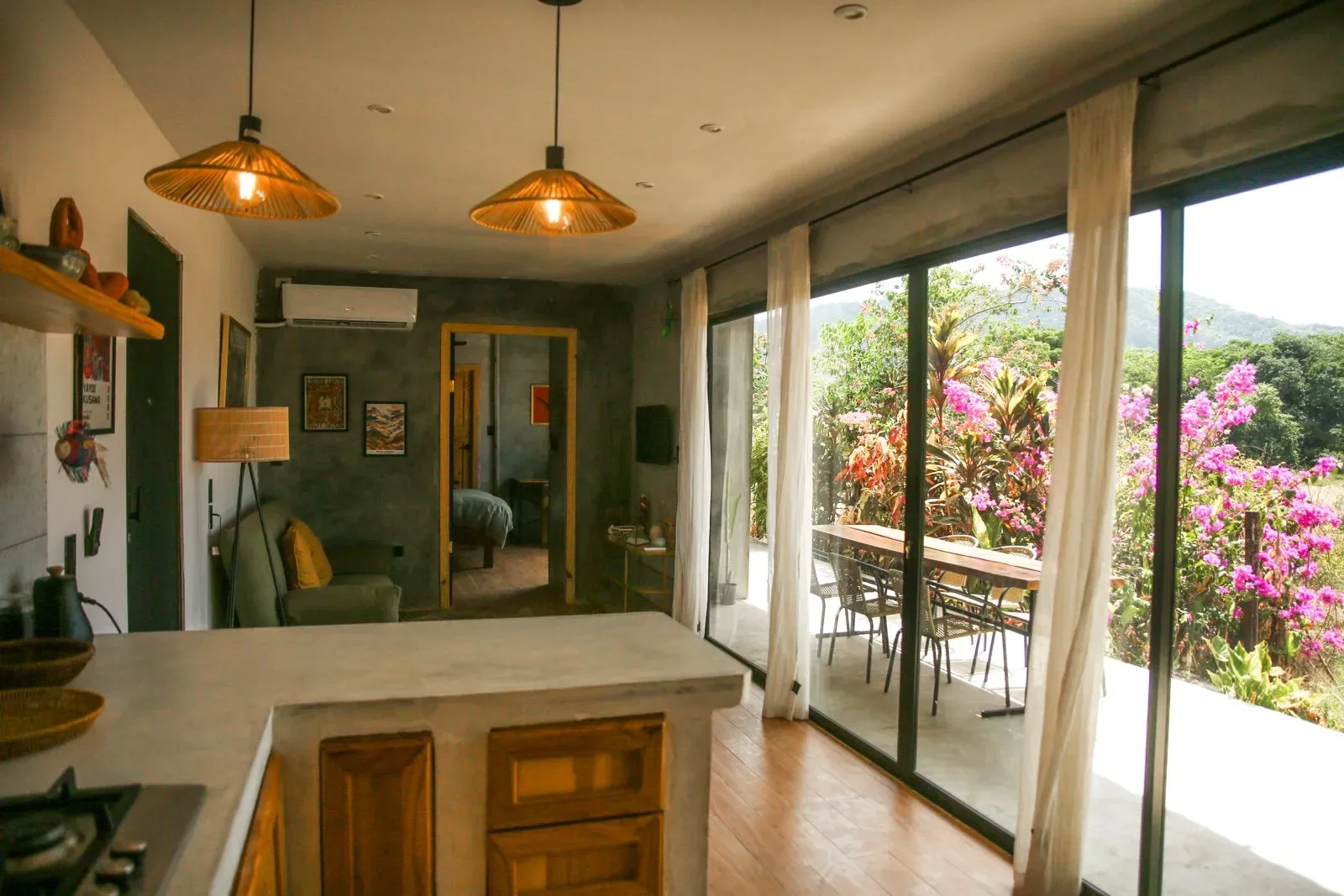 Representative hotel space: A bright kitchen opens onto a furnished patio through wide glass doors.